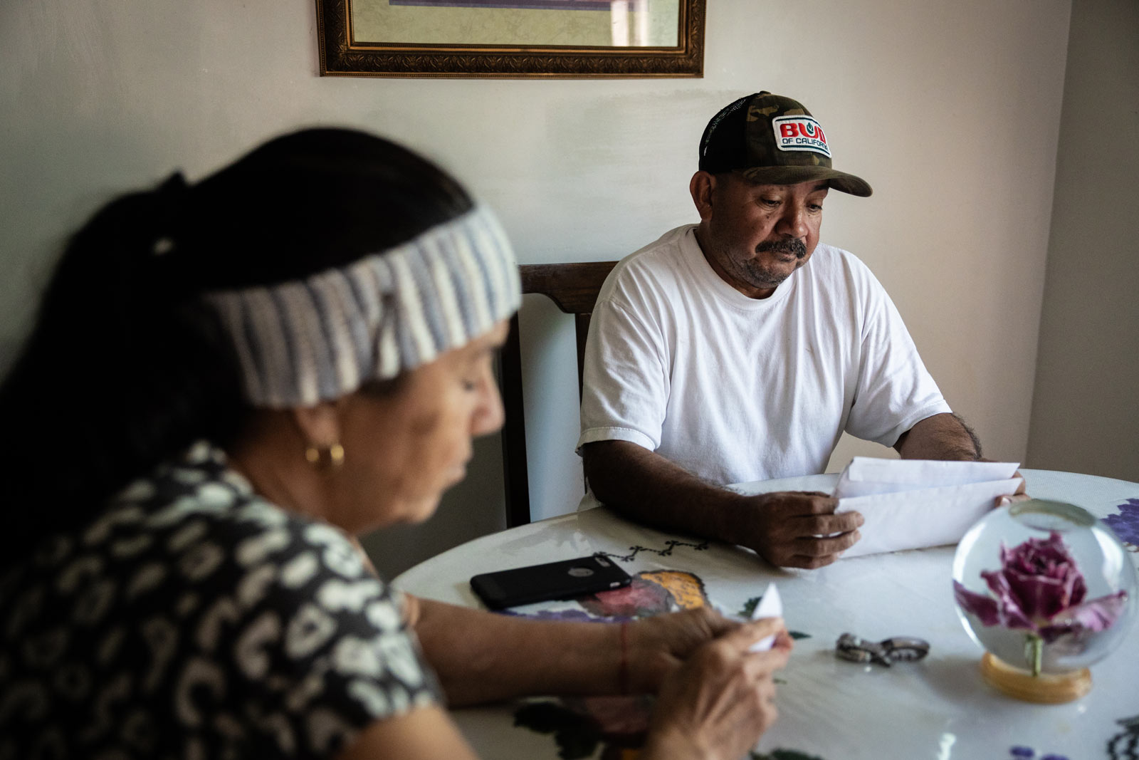 Nicanor Guillen and Angelica Guillen read mail at their kitchen table in their home in Fuller Acres.