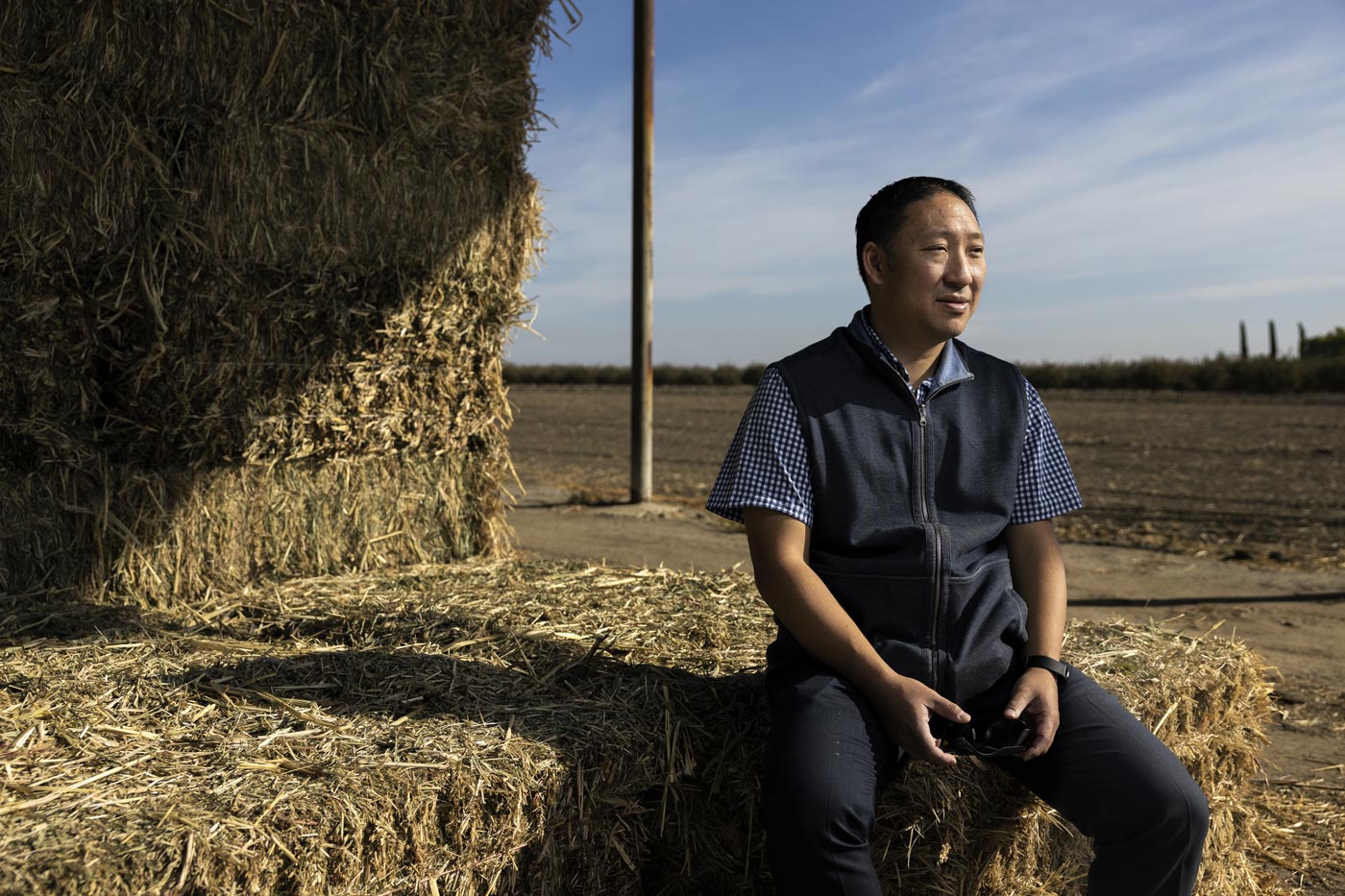 Portrait of Aaron Fukuta, sitting on a hay bale